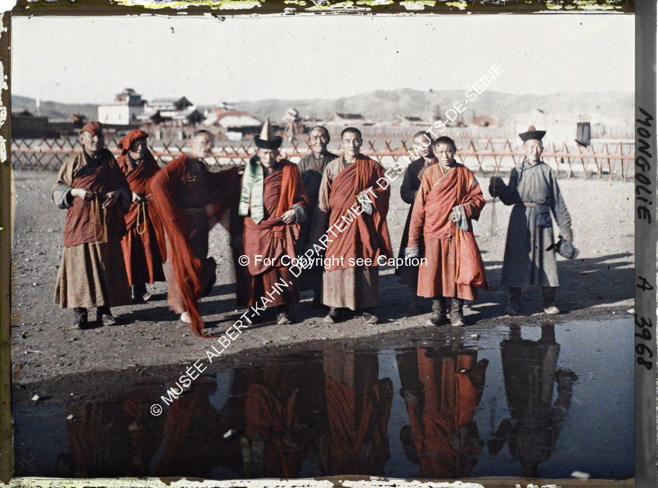Monks and laymen in front of the Yellow Palace and the Eastern part of Züün khüree with a chanting m